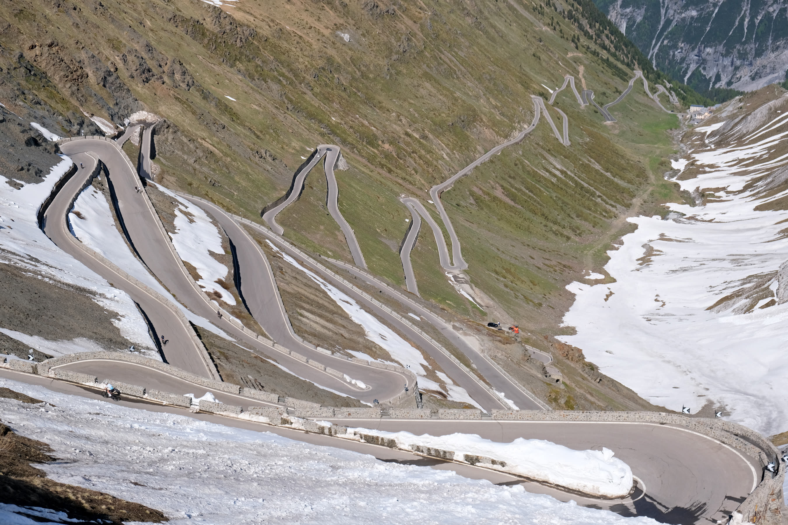 Motorcyclists on the snow-lined hairpin bends of Stelvio Pass in the Italian Alps